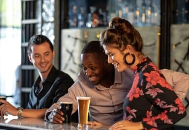 3 people looking at a printed beer