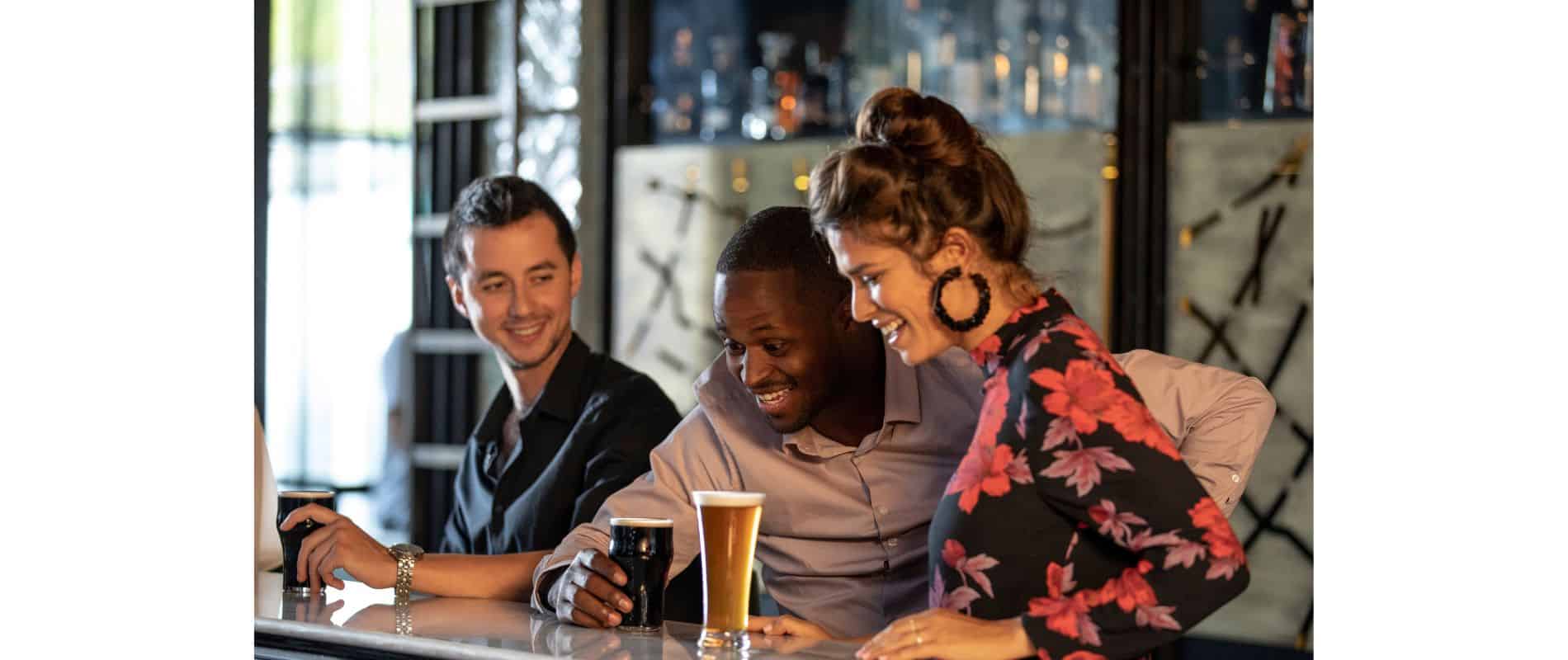 3 people looking at a printed beer